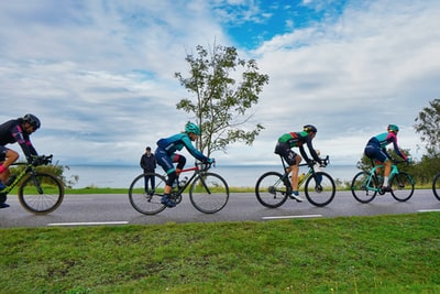 People on the road during the day to ride a bicycle
